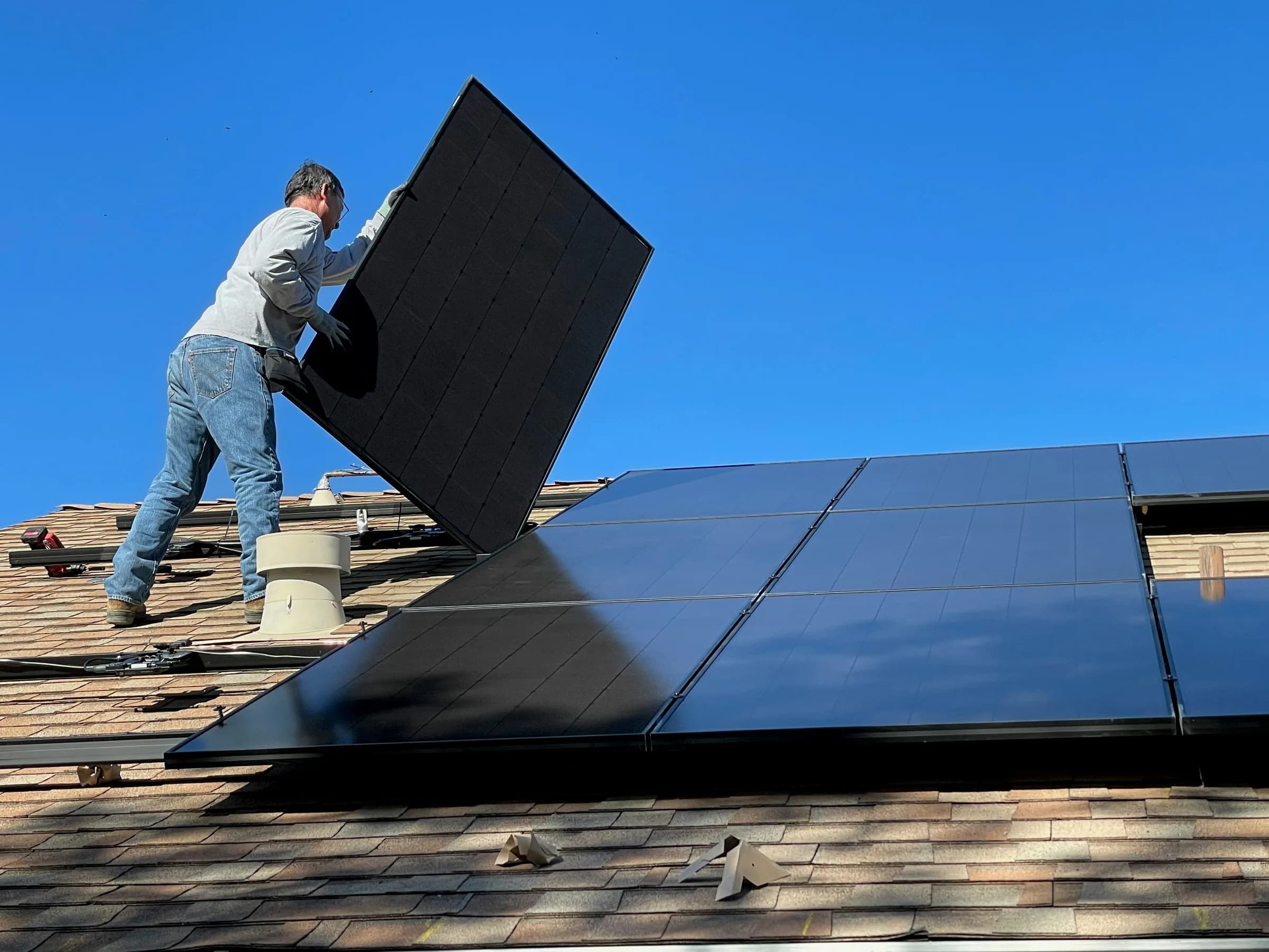 Monter postavlja solarni panel na krov